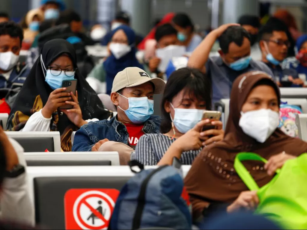 Penumpang kereta duduk di ruang tunggu di Jakarta, 5 Mei 2021. (REUTERS/Ajeng Dinar Ulfiana)