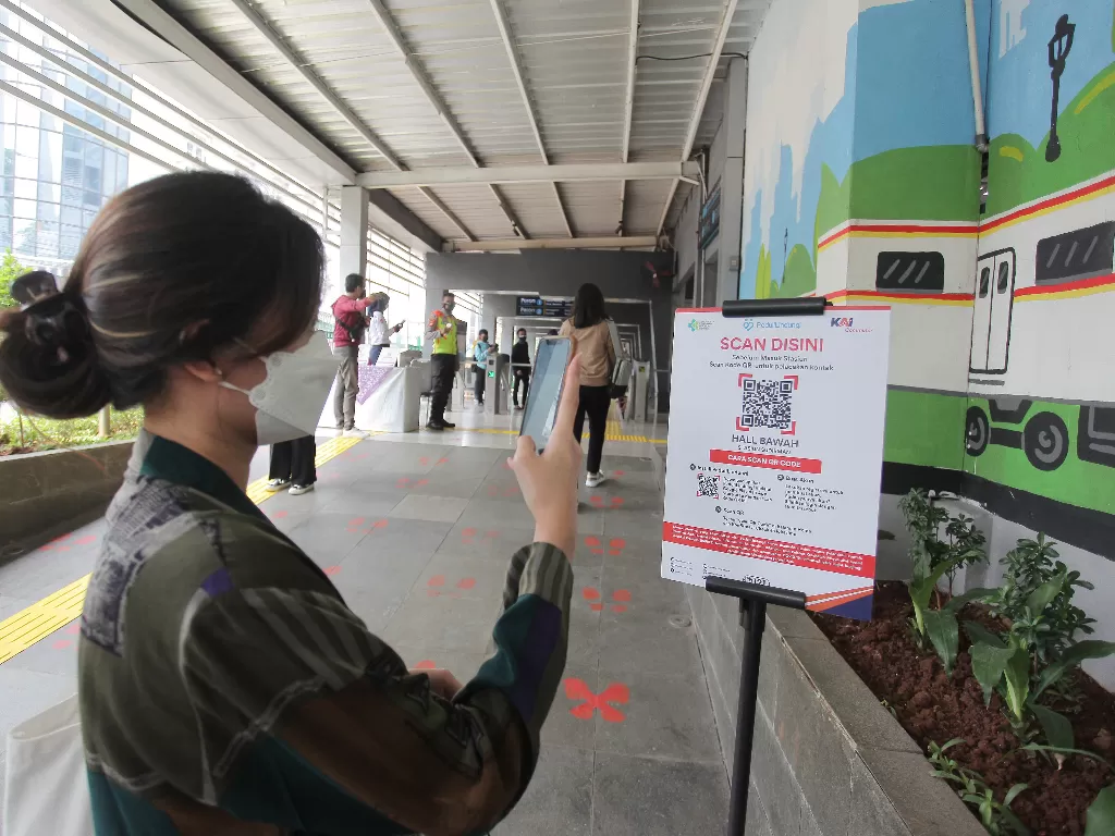 Calon penumpang memindai kode batang (QR Code) melalui aplikasi PeduliLindungi sebelum memasuki Stasiun Sudirman, Jakarta, Sabtu (11/9/2021). (photo/ANTARA FOTO/ Reno Esnir/ilustrasi)
