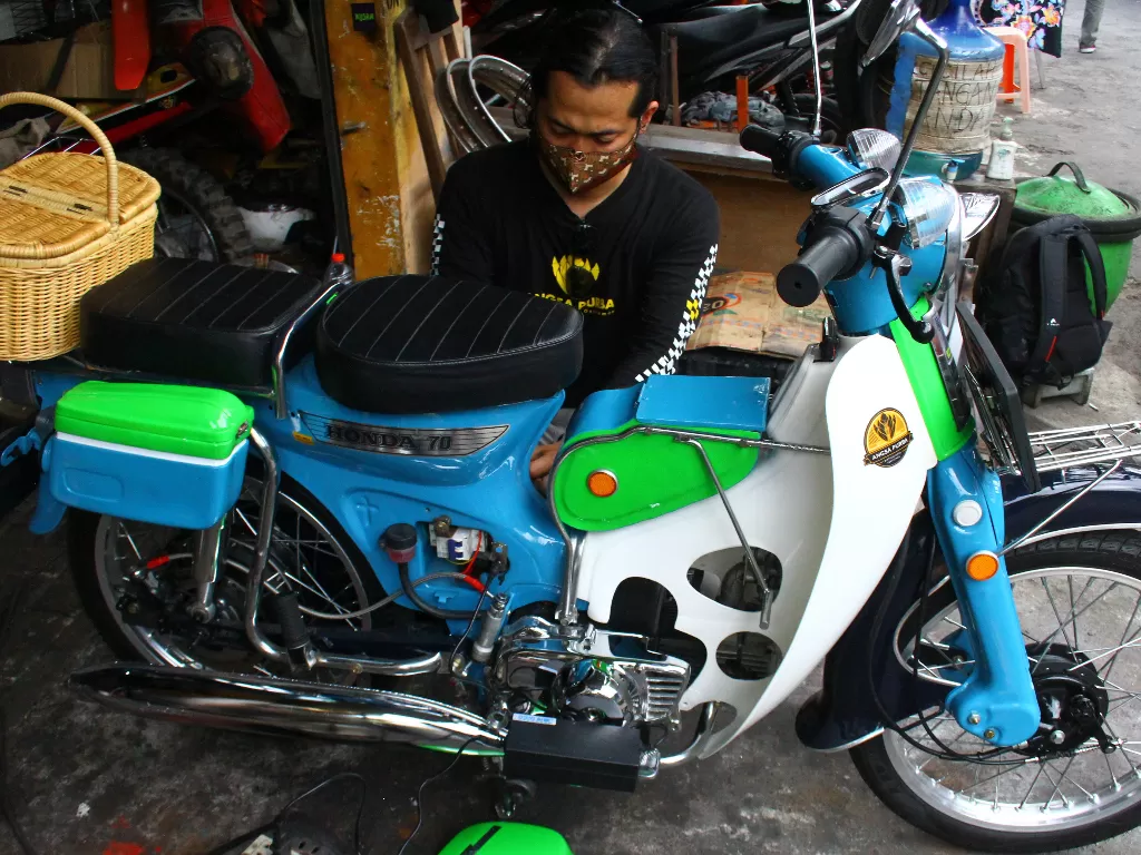 Montir Nanang Saiful Rohman mengisi ulang daya sepeda motor listrik (ANTARA FOTO/Ari Bowo Sucipto)