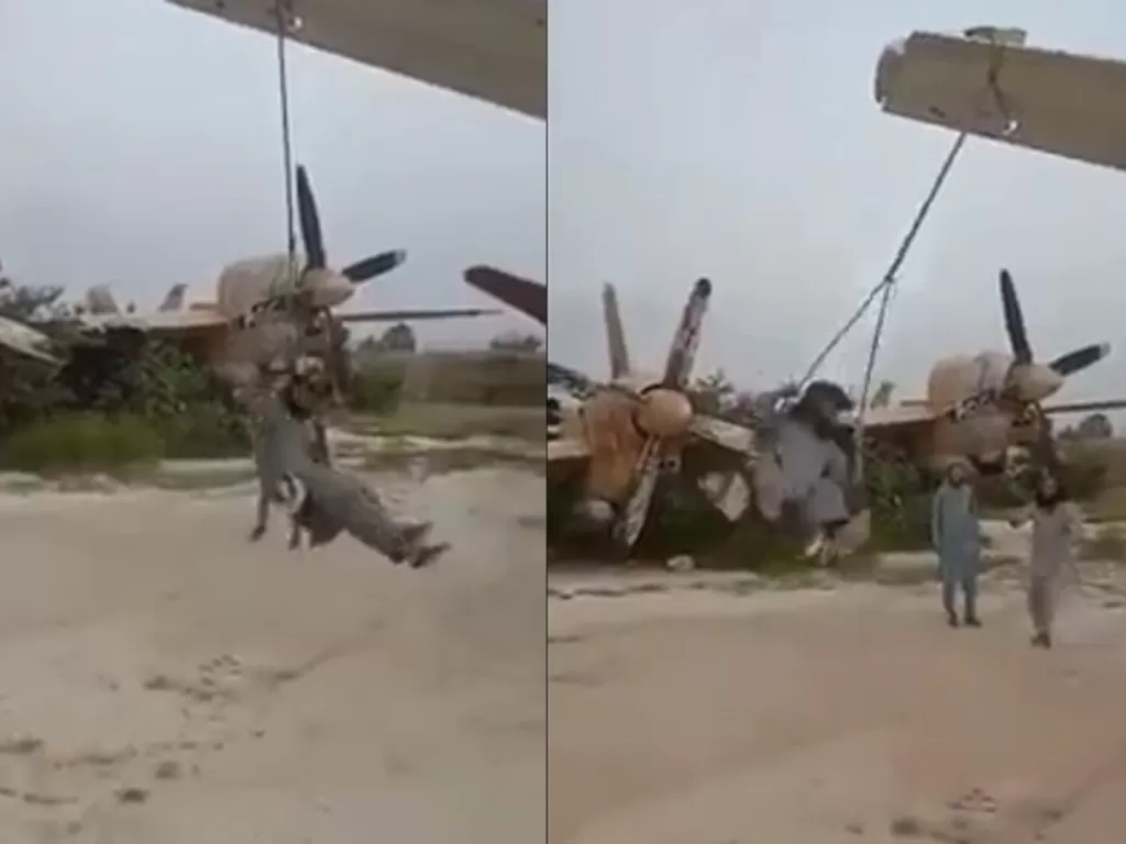 Pria Taliban bermain ayunan di kawasan diduga puing-puing pesawat bekas angkatan udara Afghanistan (Istimewa)