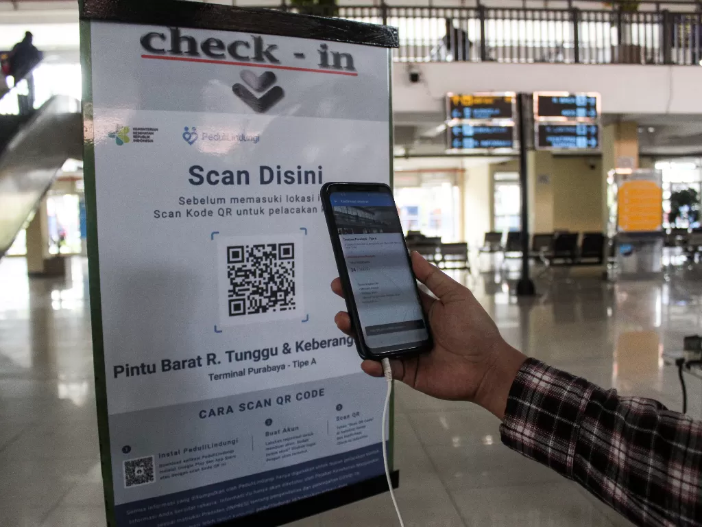 Calon penumpang melakukan scan QR code melalui aplikasi PeduliLindungi. (ANTARA FOTO/Umarul Faruq)