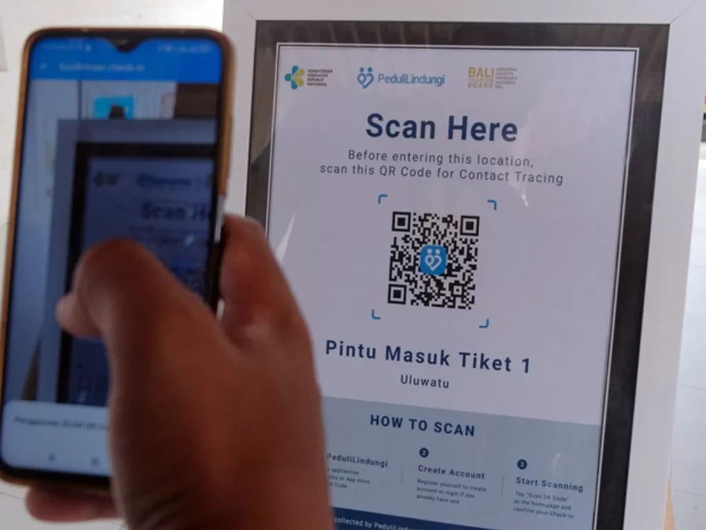 Wisatawan melakukan scan QR Code sertifikat vaksin COVID-19 melalui aplikasi PeduliLindungi. (ANTARA FOTO/Nyoman Hendra Wibowo)