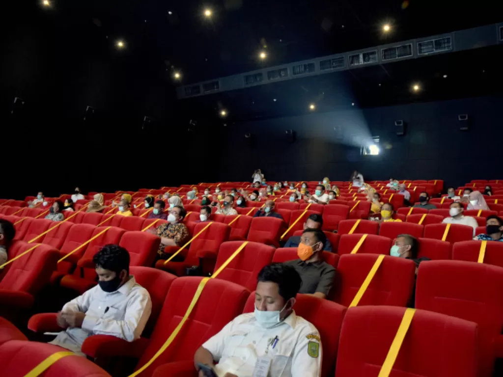 Sejumlah penonton duduk menjaga jarak di dalam studio pada hari pertama pembukaan kembali bioskop Cinepolis Cinemas, di Mal Living World, Kota Pekanbaru, Riau, Rabu (31/3/2021). (ANTARA FOTO/FB Anggoro)