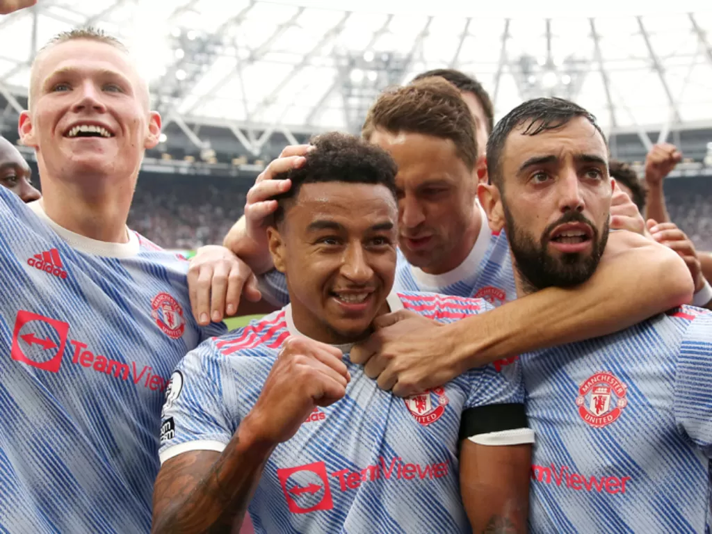 Para pemain Manchester United merayakan gol yang dicetak Jesse Lingard (tengah) ke gawang West Ham United, Minggu (19/9/2021). (REUTERS/David Klein)