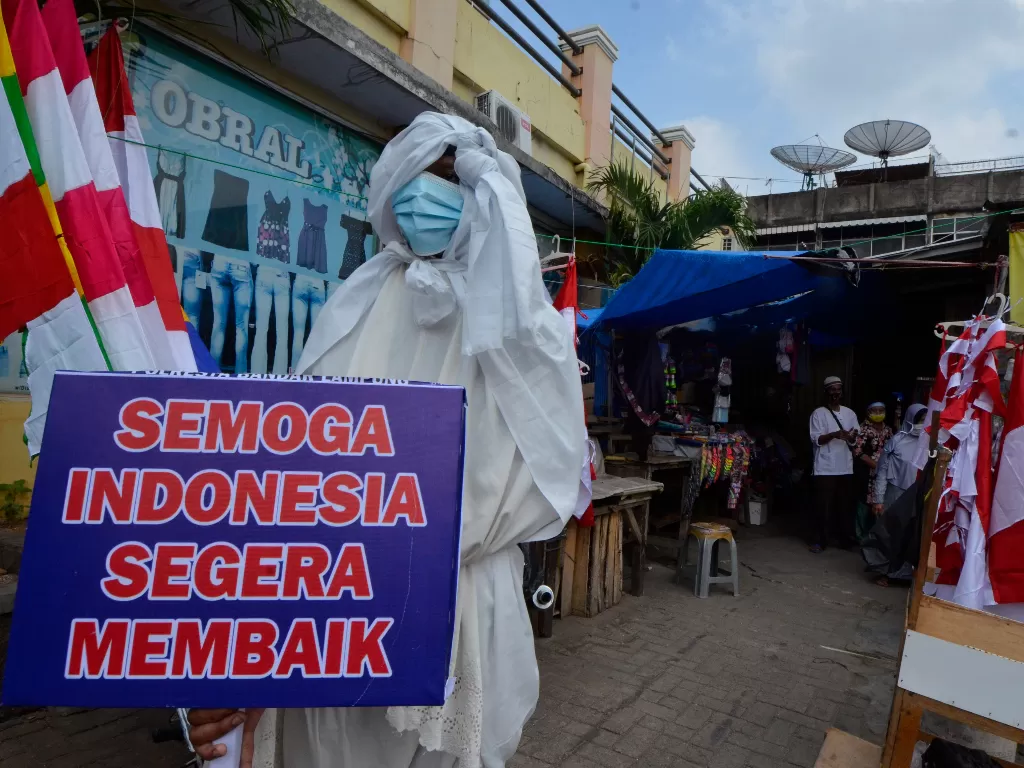Seorang anggota Satlantas Polresta Bandar Lampung menggunakan kostum pocong saat sosialisasi bahaya COVID-19 di sejumlah Pasar tradisional di Bandar Lampung, Lampung. (ANTARA FOTO/Ardiansyah).