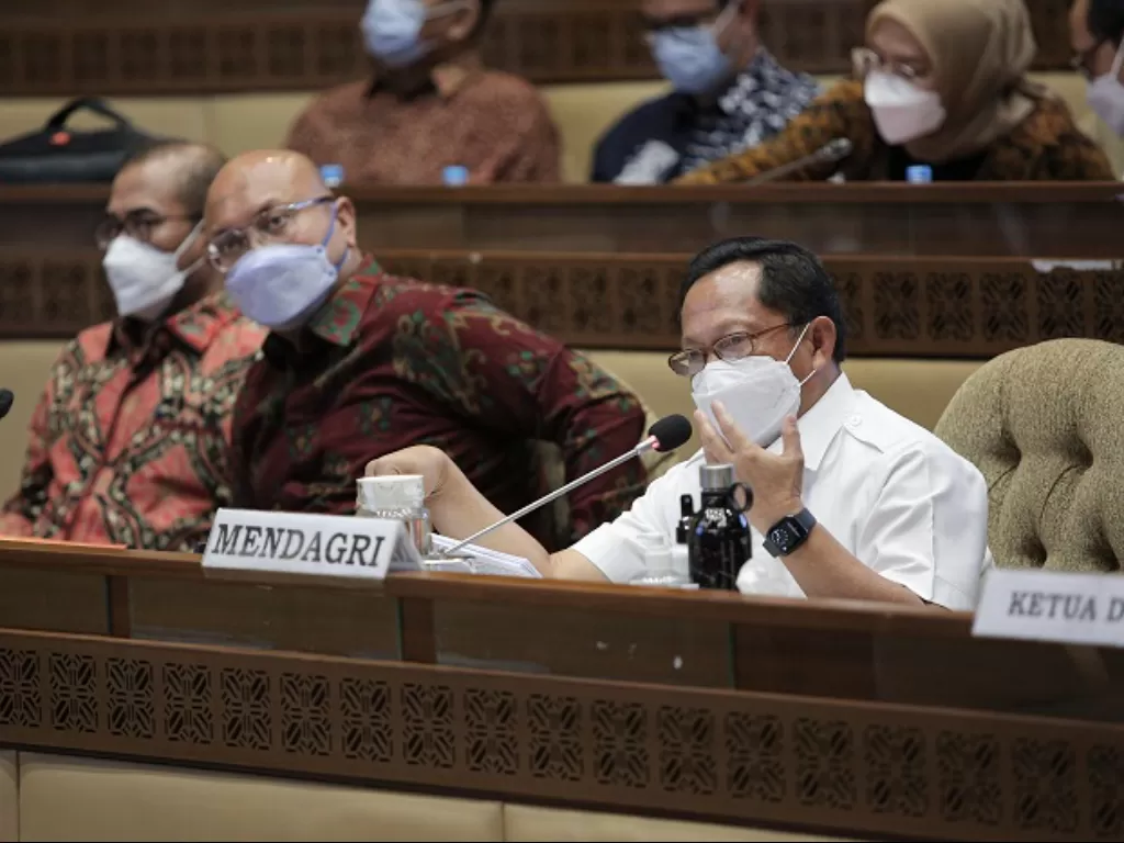 Mendagri Tito Karnavian (kanan) bersama Ketua KPU Ilham Saputra (tengah) mengikuti rapat kerja Komisi II DPR. (ANTARA FOTO/Dhemas Reviyanto)