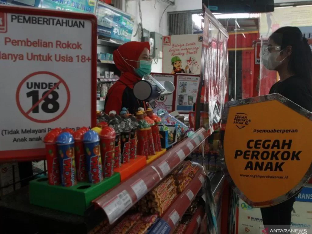 Seorang relawan melakukan edukasi tentang bahaya merokok kepada kasir sebuah toko swalayan kecil (minimarket) saat kampanye 