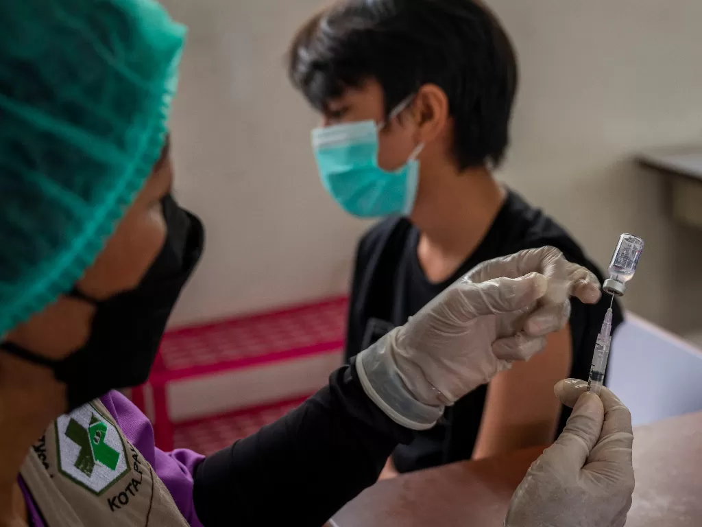  Petugas medis menyiapkan suntikan vaksin untuk seorang pelajar pada vaksinasi COVID-19 di Palu, Sulawesi Tengah, Selasa (21/9/2021). (ANTARA FOTO/Basri Marzuki)