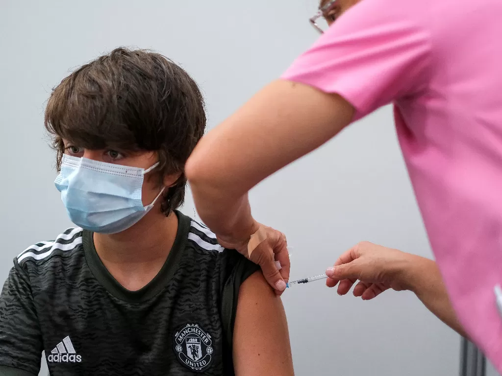 Ilustrasi remaja yang menerima suntikan vaksin Pfizer. (REUTERS/Pedro Nunes)