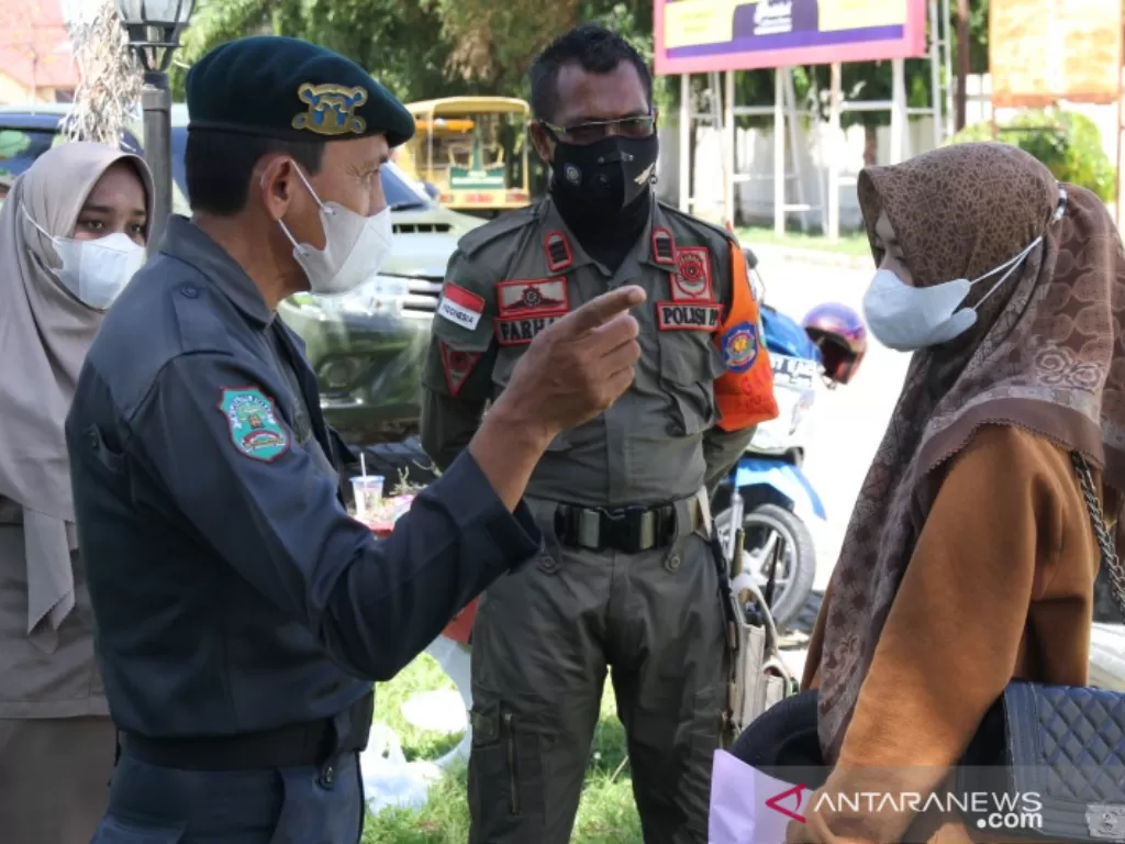 Petugas Wilayatul Hisbah memberikan nasihat kepada seorang pelanggar syariat Islam yang terjaring berbusana ketat dan tidak islami, di depan Kantor Bupati Aceh Barat di Meulaboh, Rabu (22/9/2021). (ANTARA/Teuku Dedi Iskandar)