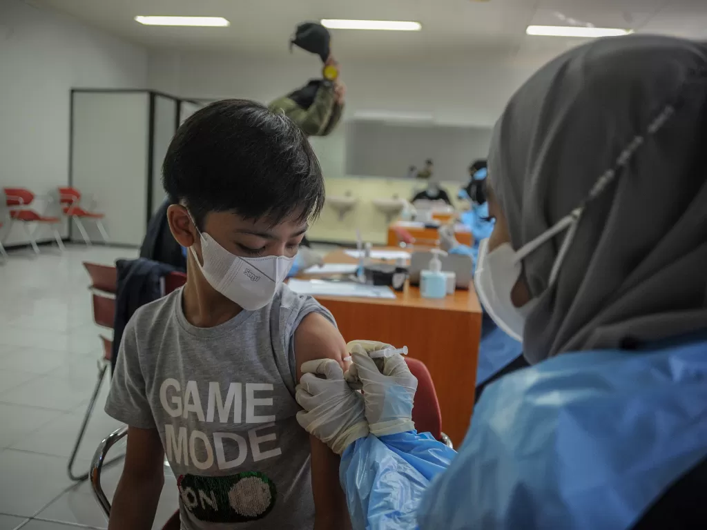 Tenaga kesehatan menyuntikkan vaksin COVID-19 kepada seorang anak saat vaksinasi massal di Sasana Budaya Ganesha (Sabuga), Bandung, Jawa Barat. (ANTARA FOTO/Raisan Al Farisi)