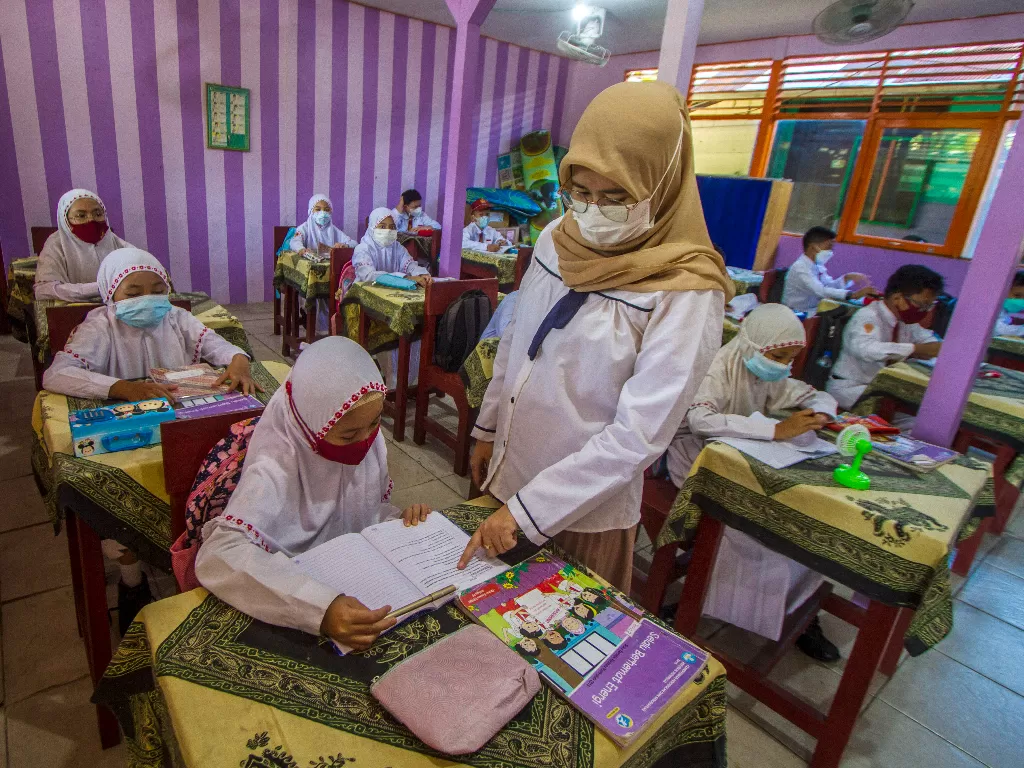 Sejumlah siswa menerima materi dari guru di SD Negeri Karang Mekar 5, Banjarmasin, Kalimantan Selatan, Senin (20/9/2021). (ANTARA FOTO/Bayu Pratama S)
