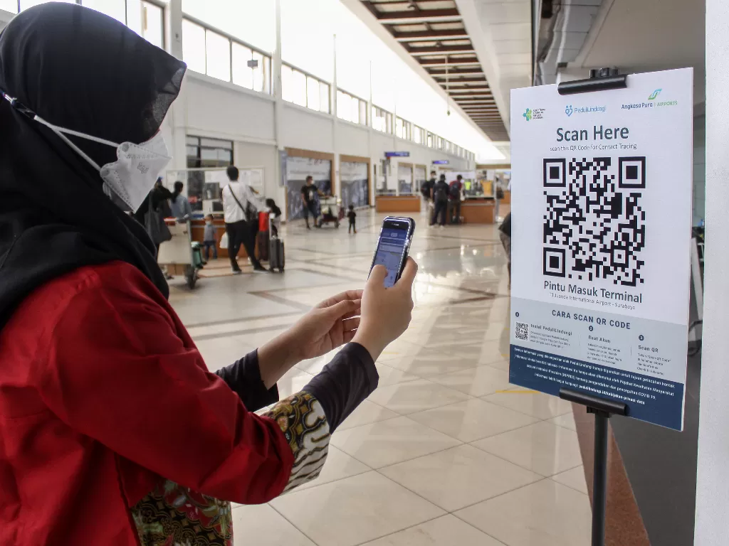 Calon penumpang pesawat melakukan scan QR code melalui aplikasi PeduliLindungi di Bandara Internasional Juanda Surabaya di Sidoarjo, Jawa Timur.  (ANTARA FOTO/Umarul Faruq)