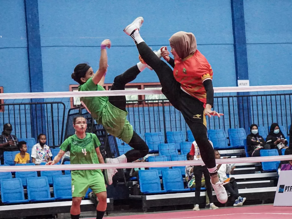 Atlet sepak takraw putri Riau Nurhidayah (kanan) berupaya menangkis bola yang dilepaskan atlet sepak takraw putri Jawa Timur Avlia Febriani (tengah). ANTARA FOTO/Indrayadi TH
