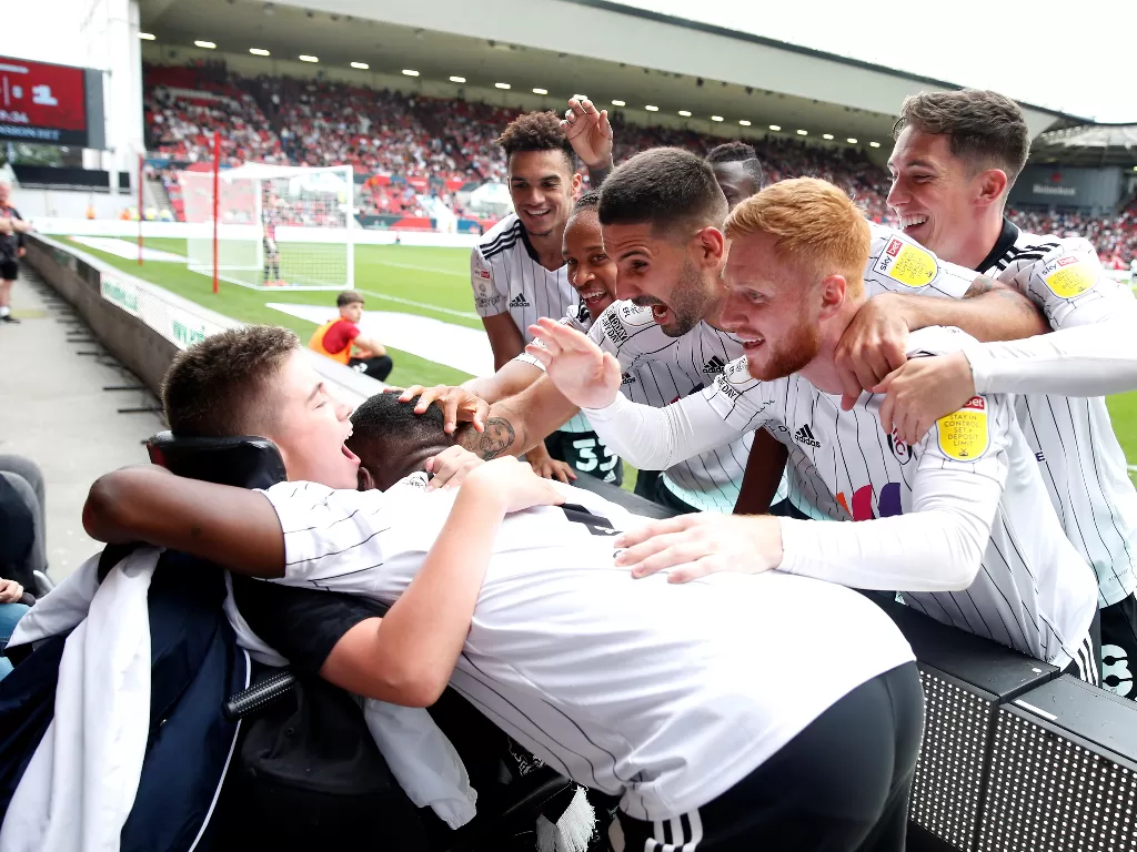Para pemain Fulham merayakan gol dengan penggemar yang duduk di kursi roda (Reuters/Paul Childs)
