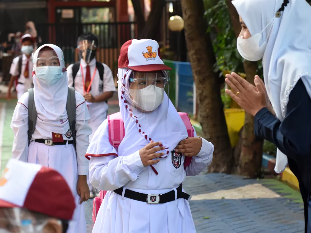Sejumlah murid antre menjaga jarak memasuki ruang kelasnya saat mengikuti kegiatan pembelajaran tatap muka (PTM) terbatas di SDN Lenteng Agung 07, Jakarta. (ANTARA FOTO/Indrianto Eko Suwarso)