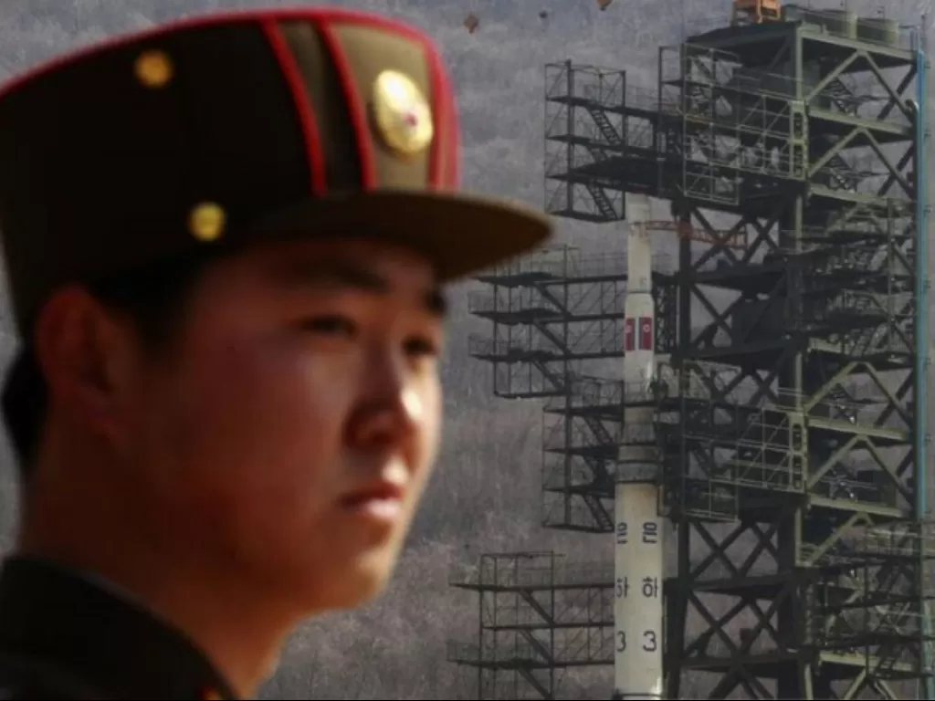 Seorang tentara berjaga di depan roket Unha-3 di lokasi peluncuran satelit Laut Barat, barat laut Pyongyang. (REUTERS)