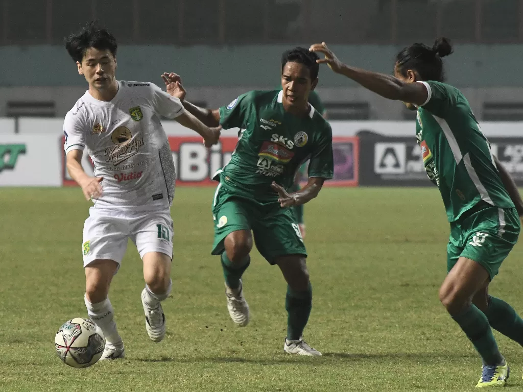 Pesepak bola Persebaya Surabaya Marukawa (kiri) berebut bola dengan dua pesepak bola PSS Sleman (ANTARA FOTO/Fakhri Hermansyah/rwa.)