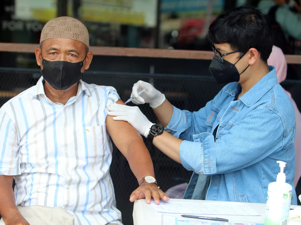 Tenaga medis menyuntikkan vaksin kepada warga saat giat vaksinasi di kawasan pusat perdagangan di Jalan Gajahmada, Pontianak.  (ANTARA/Jessica Helena Wuysang)