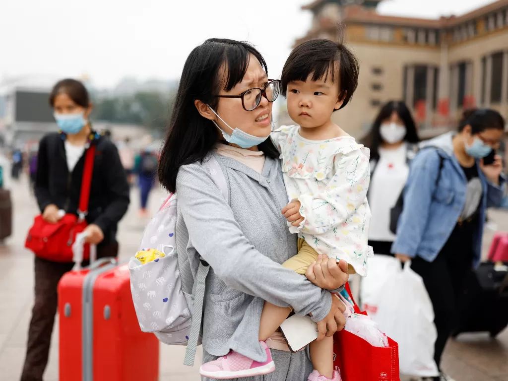 Seorang ibu di China menggendong anaknya (REUTERS/Carlos Garcia Rawlins)