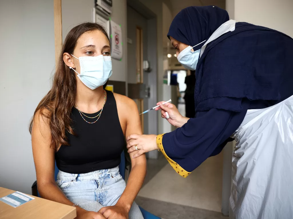 Tampilan orang yang vaksinasi COVID-19. (photo/REUTERS/HENRY NICHOLLS)