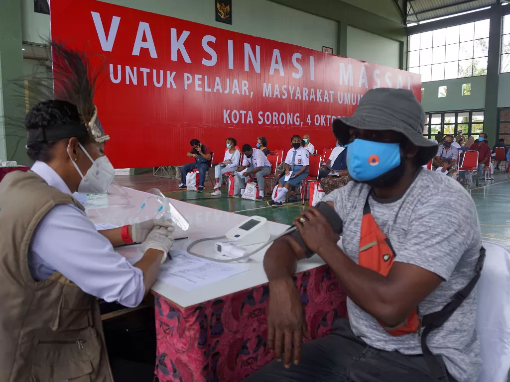 Petugas memeriksa kesehatan warga sebelum menyuntikan vaksin COVID-19 di gedung serba guna Natalyon 762 Vira Yudha Sakti Kota Sorong, Papua Barat. (ANTARA FOTO/Olha Mulalinda)