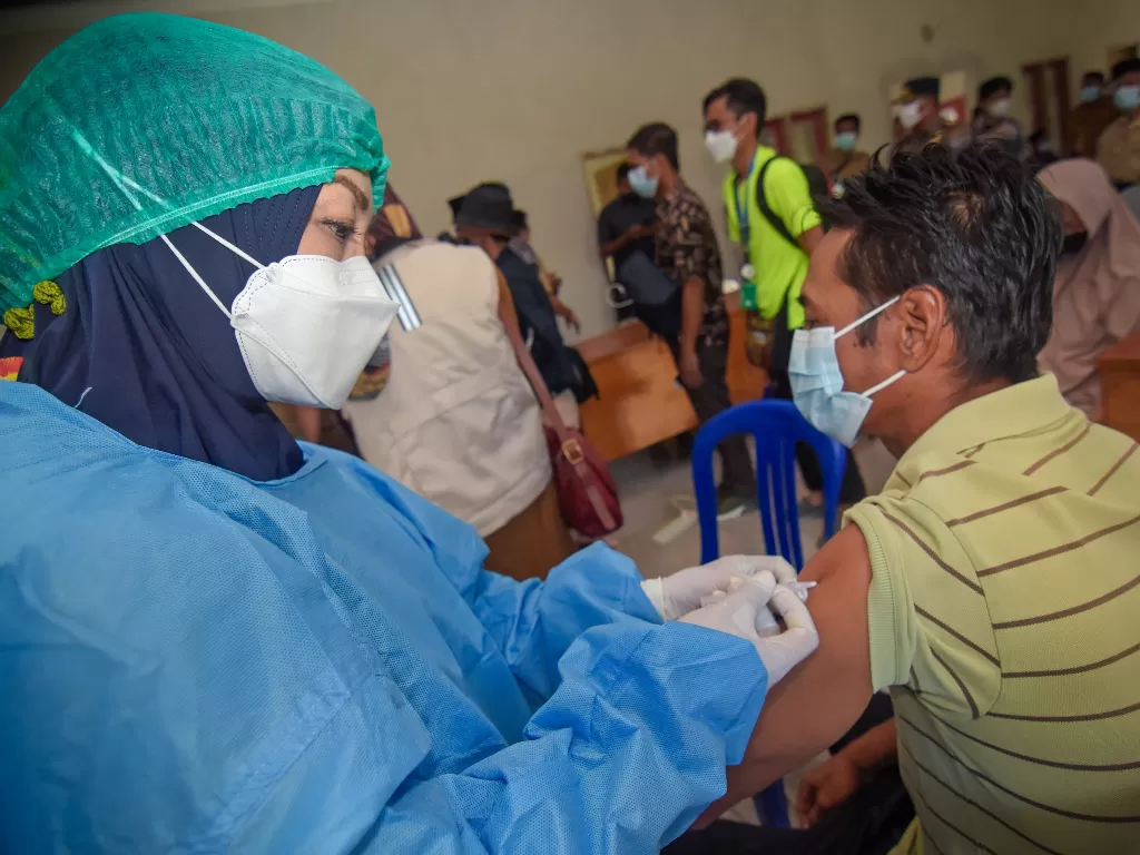  Petugas menyuntikkan vaksin COVID-19 kepada warga di Kantor Desa Tanak Awu, Kecamatan Pujut, Praya, Lombok Tengah, NTB, Senin (4/10/2021). (photo/ANTARA FOTO/Ahmad Subaidi/iilustrasi)
