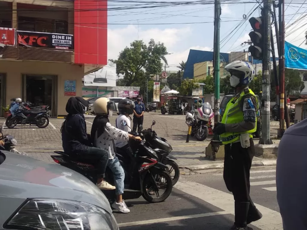 Pengendara sepeda motor saat berhenti di traffict light Jalan Sudirman Medan. (Foto/Indozone.id)