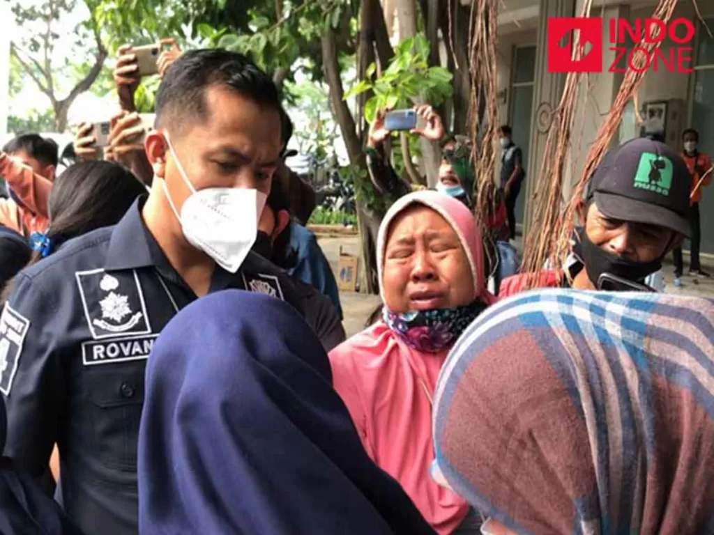 Seorang ibu menangis usai lihat penggerebekan kantor pinjol di Tangerang. (INDOZONE/Samsudhuha Wildansyah).