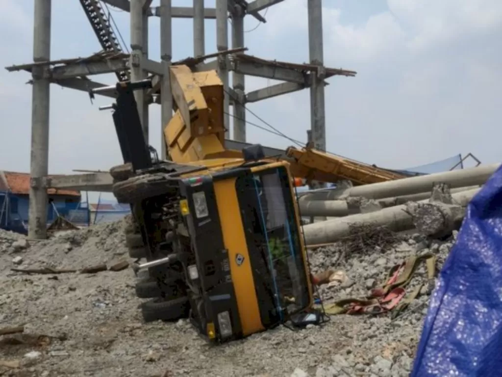 Truk pengangkut crane terguling di lokasi proyek PDAM di Jalan Mawar, Pancoran Mas, Depok, Jumat (15/10/2021). (Istimewa)