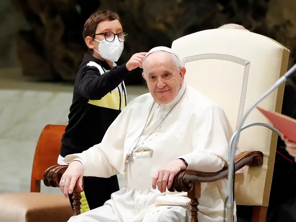 Seorang bocah berusaha mengambil topi Paus Fransiskus. (Photo/Reuters)