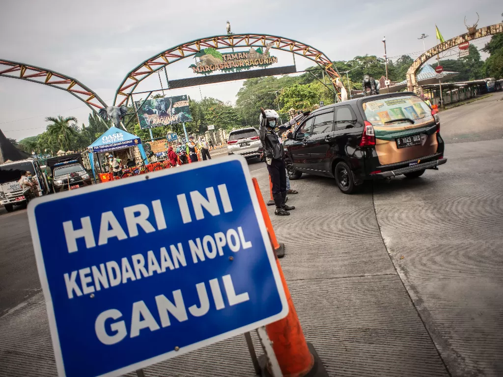 Petugas Dishub DKI Jakarta mengatur arus lalu lintas di depan pintu masuk Taman Margasatwa Ragunan. (ANTARA FOTO/Aprillio Akbar)