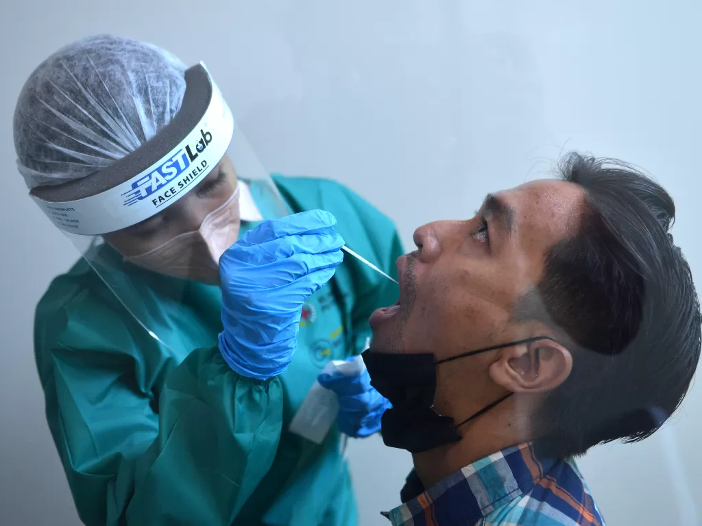 Petugas kesehatan melakukan pengambilan sampel untuk pemeriksaan RT-PCR saat simulasi penerbangan internasional di Bandara Internasional I Gusti Ngurah Rai, Badung, Bali. (Foto/ANTARA/Fikri Yusuf)