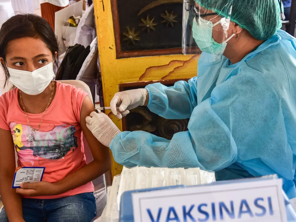 Seorang tenaga kesehatan menyuntik vaksin COVID-19 kepada anak saat vaksinasi massa di Lapangan Merdeka, Kota Ambon, Maluku, Senin (4/10/2021).  (ANTARA FOTO/FB Anggoro)