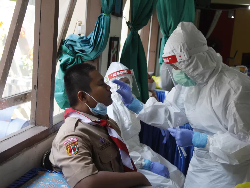 Petugas kesehatan melakukan tes usap PCR kepada siswa di SMP Negeri 8 Solo, Jawa Tengah. (ANTARAFOTO/Maulana Surya)