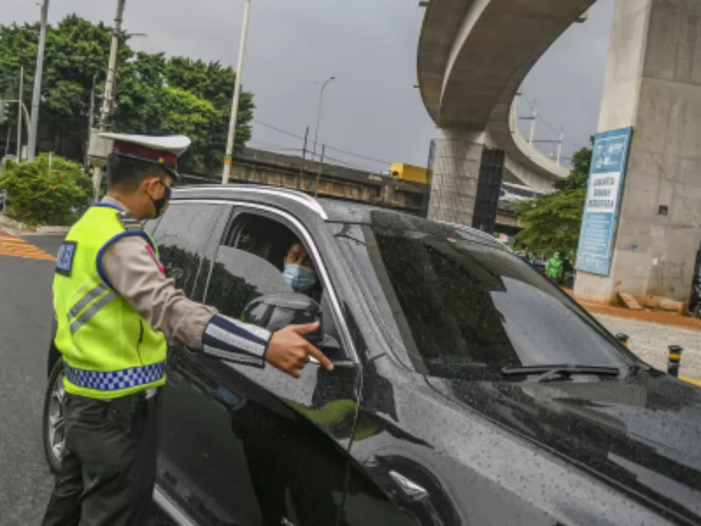 Petugas Kepolisian mensosialisasikan aturan penerapan sistem ganjil-genap kepada pengendara di Jalan Farmawati, Jakarta, Senin (25/10/2021). (ANTARA FOTO/Galih Pradipta/rwa)
