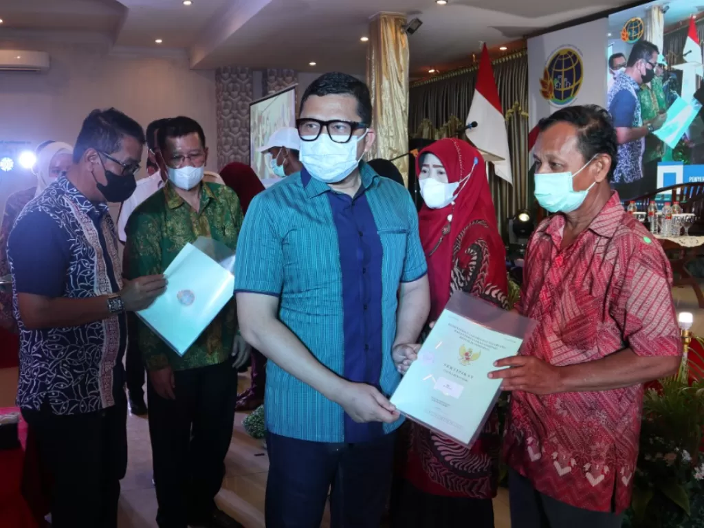 Ketua Komisi II DPR RI Ahmad Doli Kurnia Tandjung menyerahkan sertifikat kepada salah seorang warga. (Ist)