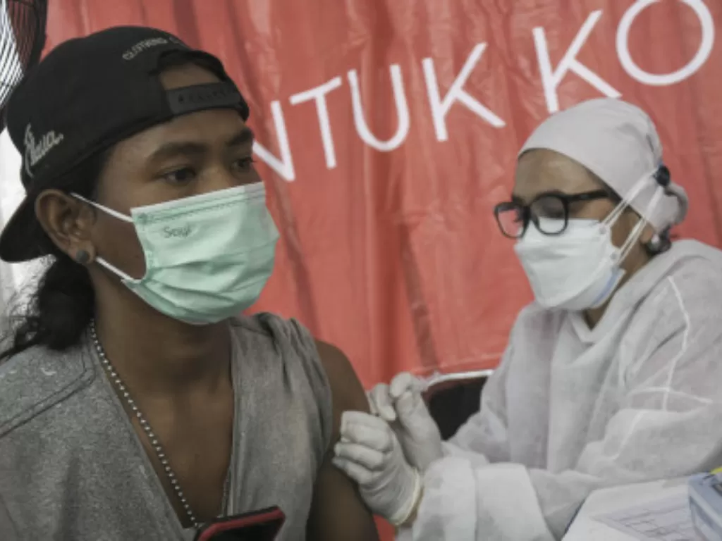 Petugas medis menyuntikkan vaksin COVID-19 kepada pemulung dan pengepul sampah di Tempat Pembuangan Sampah Terpadu (TPST) Bantargebang, Bekasi, Jawa Barat, Jumat (29/10/2021). (ANTARA FOTO/ Fakhri Hermansyah)