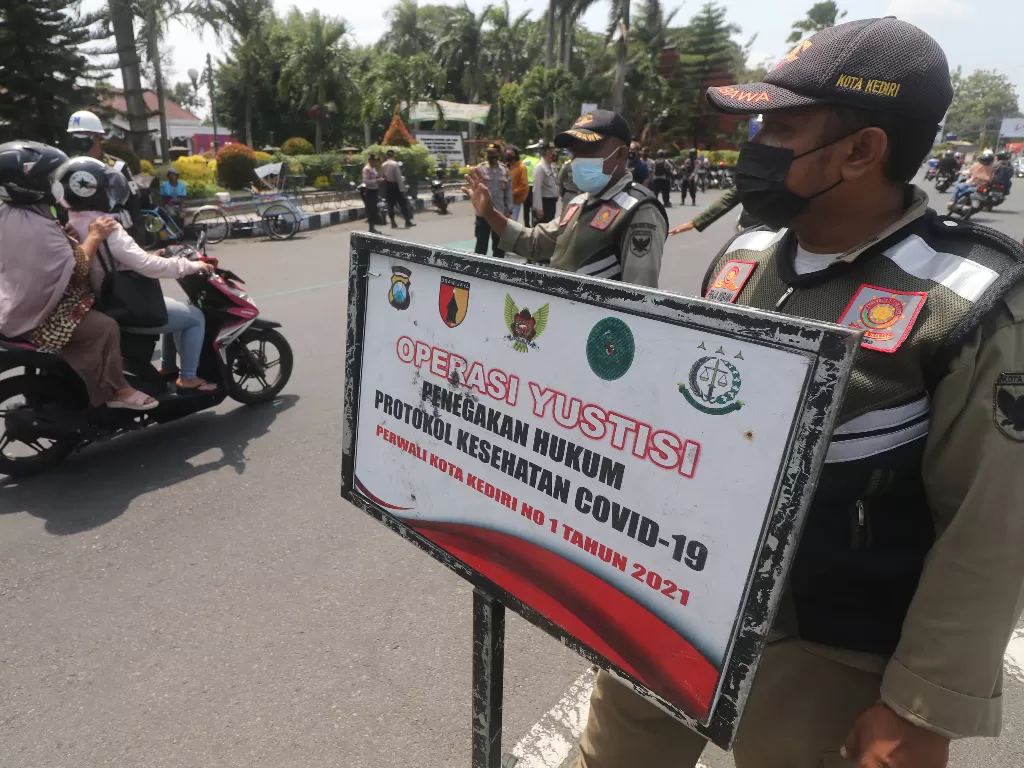 Petugas gabungan melakukan razia penegakan protokol kesehatan COVID-19 di Kota Kediri, Jawa Timur, Selasa (26/10/2021).  (ANTARA FOTO/Prasetia Fauzani)