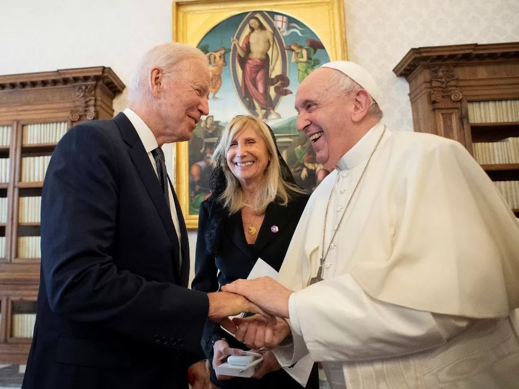 Momen Presiden AS Joe Biden memberikan koin kepada Paus Fransiskus di Vatikan, Jumat (29/10/2021) (Vatican Media via REUTERS)