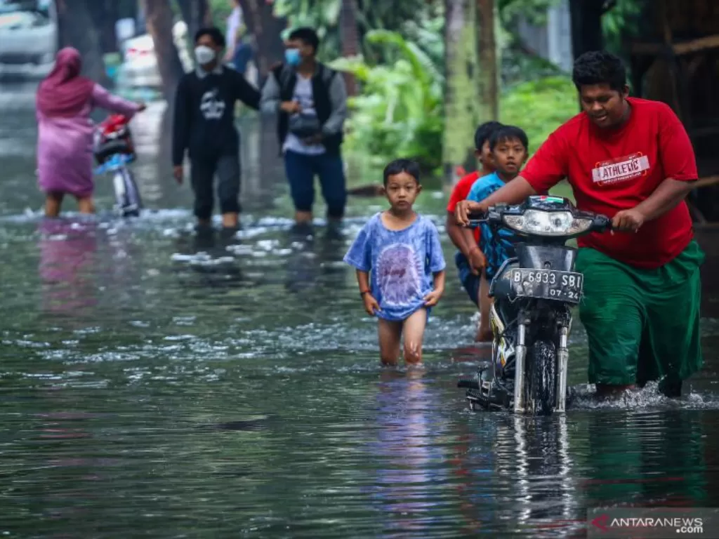 Warga mendorong motornya melintasi banjir di kawasan Joglo, Jakarta, Senin (25/10/2021). (photo/ANTARA FOTO/Rivan Awal Lingga/ilustrasi)