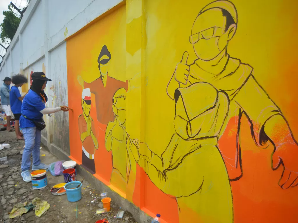 Peserta menyelesaikan karya muralnya saat Lomba Mural Bhayangkara bertema tentang pandemi COVID-19, di Sawahan, Padang, Sumatera Barat, Sabtu (30/10/2021). (ANTARA FOTO/Iggoy el Fitra).