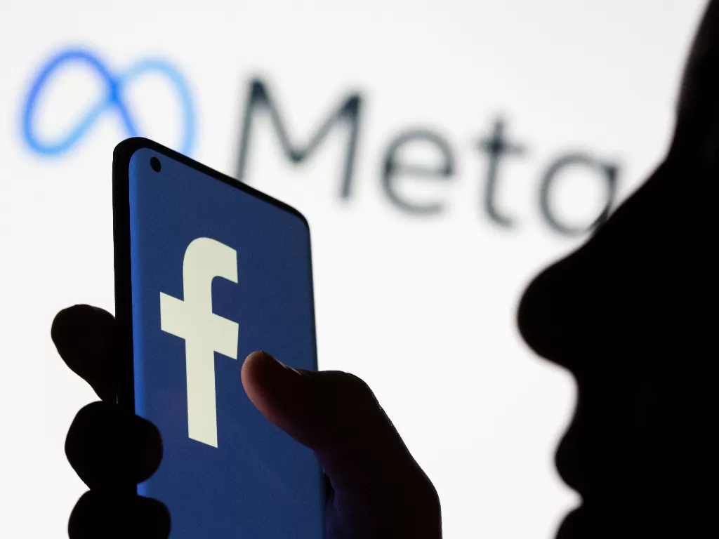 Ilustrasi smartphone berlogo Facebook di depan logo baru Facebook yang di-rebranding Meta. (REUTERS/Dado Ruvic)