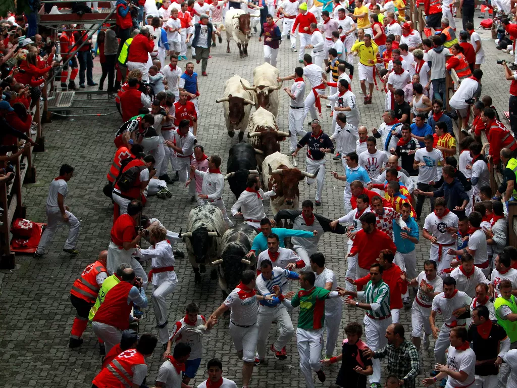  Ilustrasi: Pelari berlari di depan Torrestrella yang melawan banteng di pintu masuk arena adu banteng saat lomba lari pertama banteng di festival San Fermin di Pamplona 7 Juli 2014.  (photo/REUTERS/Joseba Etxaburu/Ilustrasi)
