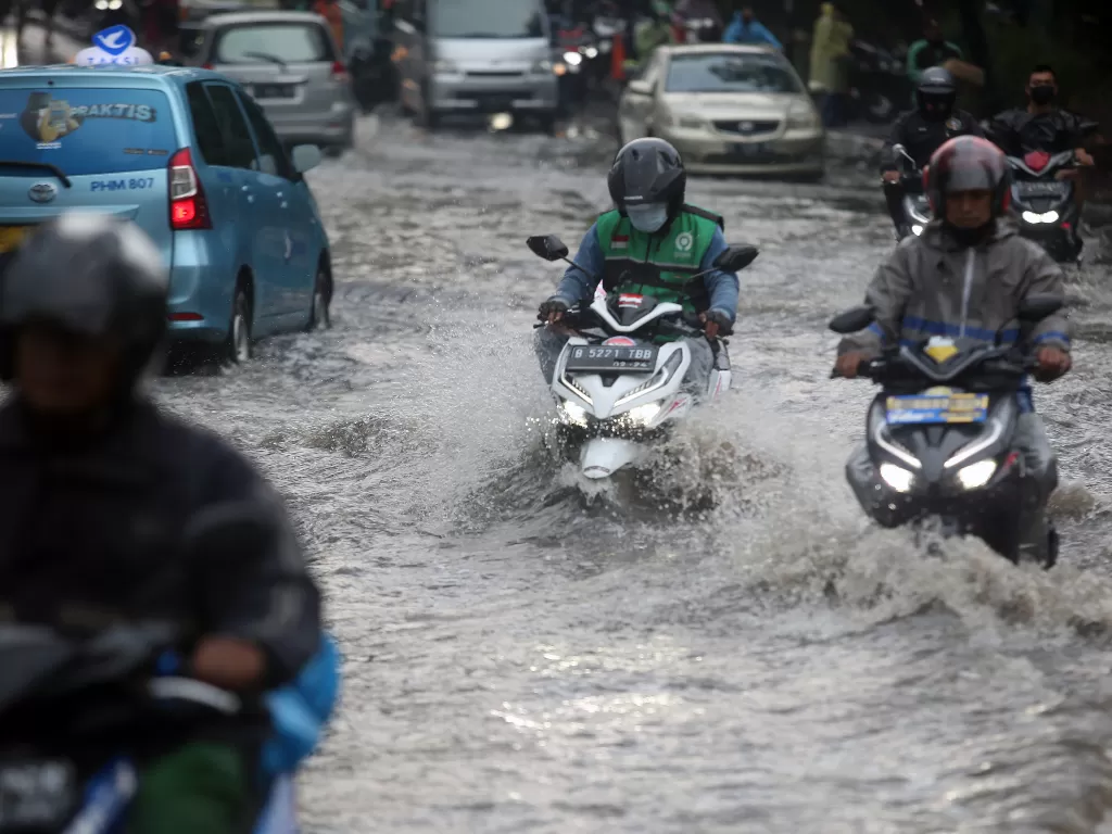 Pengendara motor menerobos banjir di Jalan Raya Kebayoran Lama, Jakarta. (ANTARA FOTO/Muhammad Iqbal)