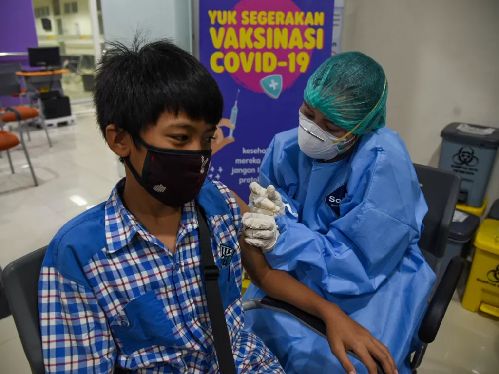 Petugas kesehatan menyuntikkan vaksin COVID-19 dari Sinovac kepada seorang anak saat pelaksanaan vaksinasi di Rumah Sakit?Adam Malik, Kota Medan, Sumatera Utara, Selasa (2/11/2021). (ANTARA FOTO/FRANSISCO CAROLIO).