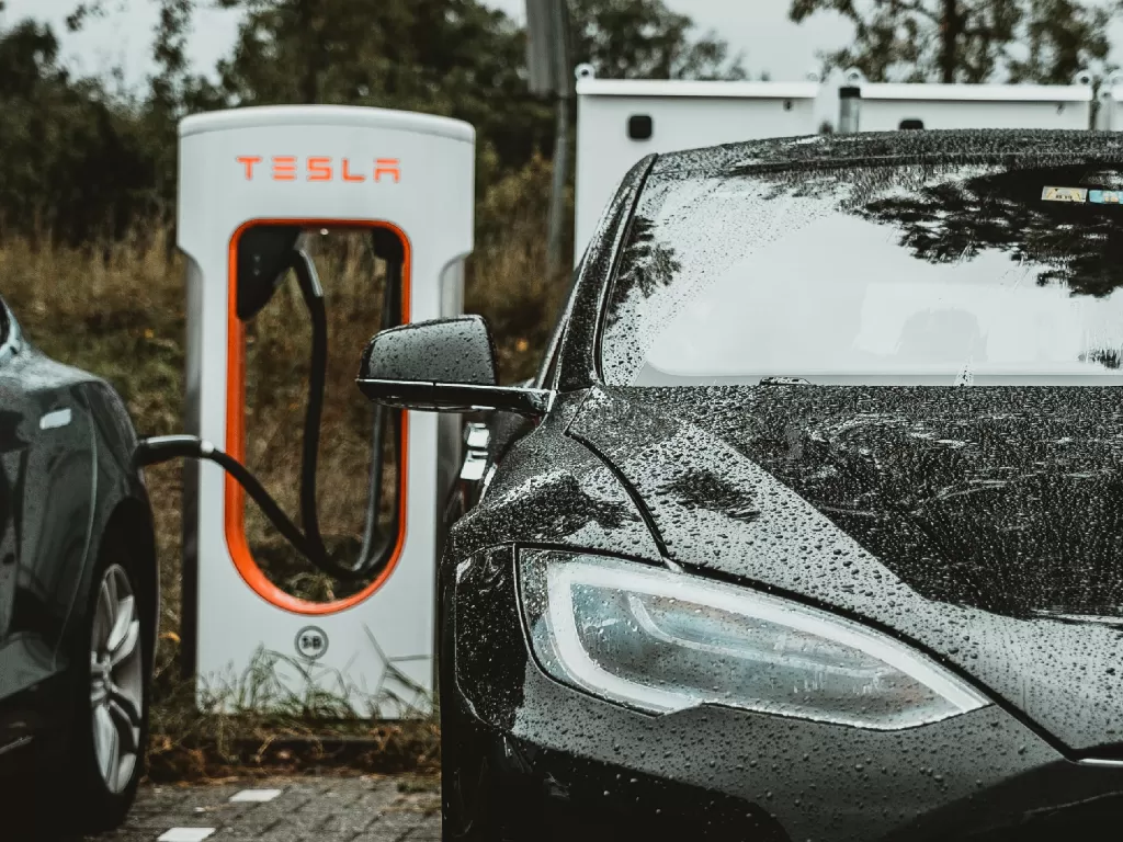 Mobil Tesla yang sedang melakukan pengisian daya (Ilustrasi/Unsplash/Andreas Dress)