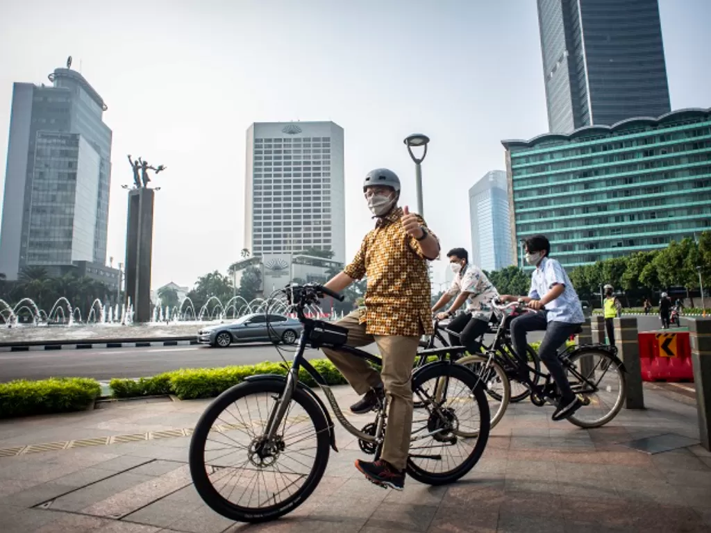 Gubernur DKI Jakarta Anies Baswedan (kiri) memakai baju batik bersepeda di kawasan Bundaran HI, Jakarta. (ANTARA FOTO/Aprillio Akbar)