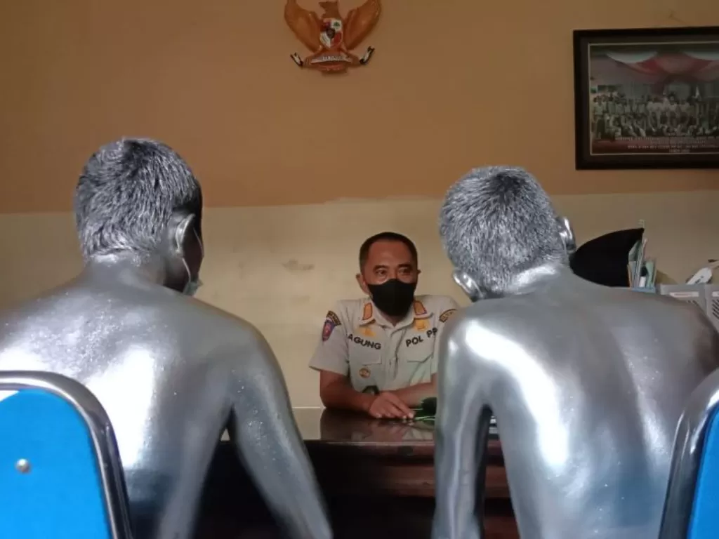 Petugas meminta keterangan dua manusia silver yang diduga melakukan pelecehan terhadap pengguna jalan di Kota Tulungagung, Rabu (3/11/2021). (ANTARA/Destyan Sujarwoko)