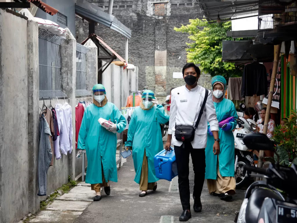 Petugas kesehatan berjalan menuju rumah warga untuk melakukan vaksinasi COVID-19 di Sondakan, Laweyan, Solo, Jawa Tengah, Kamis (4/11/2021).  (ANTARA FOTO/Maulana Surya).